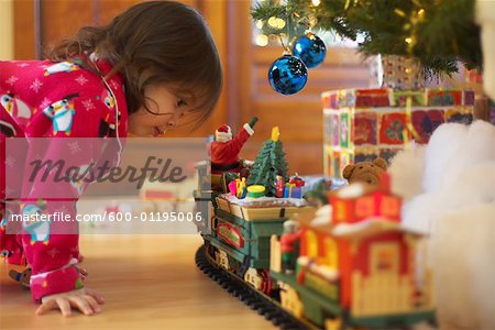 Little Girl Looking at Toy Train