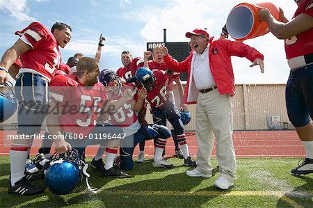Football Players Pouring Water over Coach
