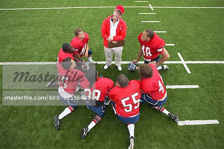 Coach Talking to Football Players in Huddle