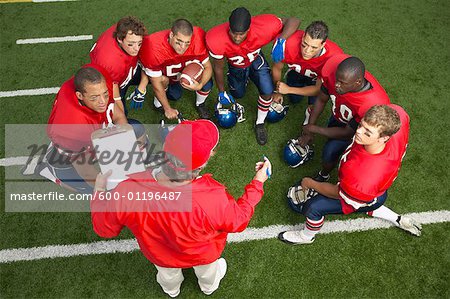 Coach Talking to Football Players in Huddle