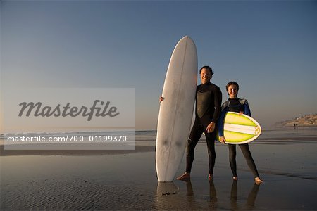 Vater und Sohn am Strand mit Surfboards