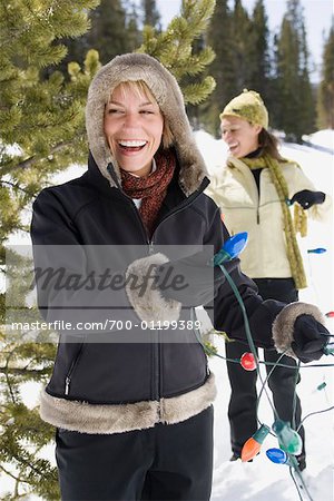 Women Putting Christmas Lights on Tree