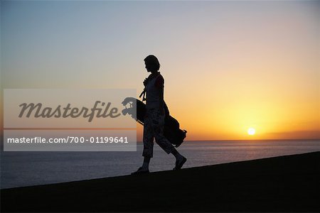 Femme avec sac de Golf au crépuscule