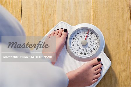 Femme se tenant sur des échelles de poids