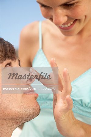 Woman Putting Sunscreen on Man's Nose