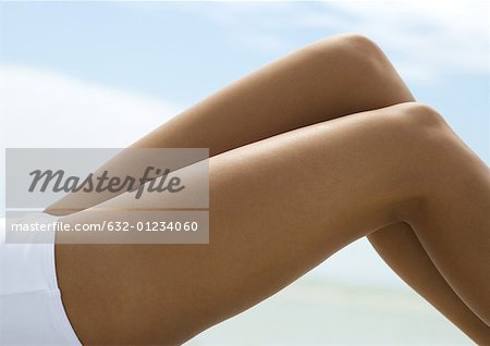 Femme allongée avec les genoux vers le haut, les jambes nues en gros plan