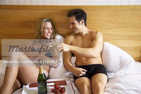 Couple in Bed With Food and Champagne