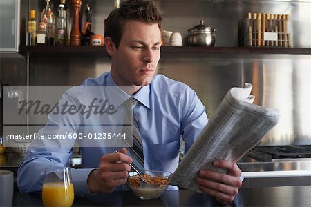 Homme journal de lecture pendant le petit déjeuner