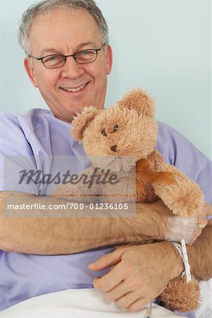 Man in Hospital Bed, Holding Teddy Bear