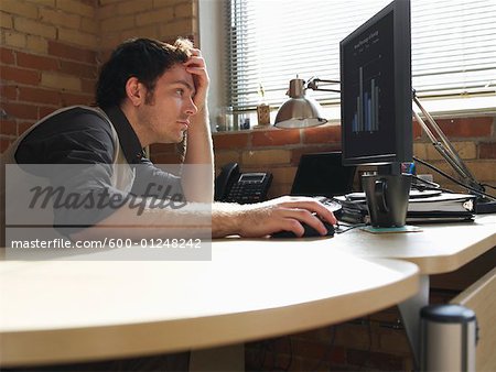 Man Looking at Graph on Computer