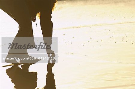 Woman Picking Something out of Sand