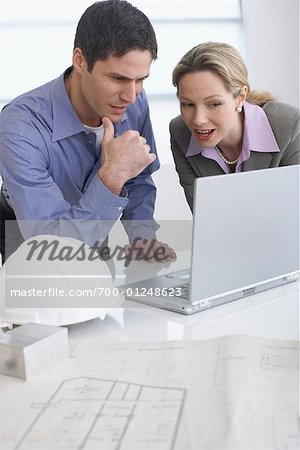 Homme et femme sur chantier avec ordinateur portable