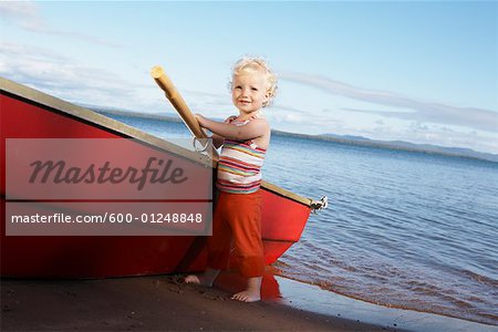 Girl Standing by Rowboat
