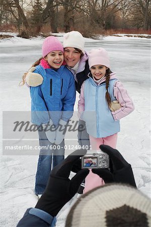 Father Taking Picture of Family Skating
