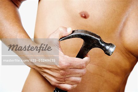 Mid section view of a man holding a claw hammer