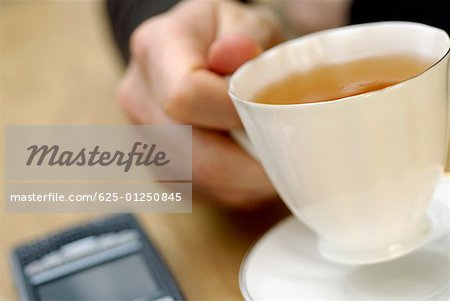 Close-up of a person's hand holding a cup of tea