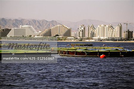 Fish farms in the sea with buildings in the background, Red Sea, Eilat, Israel