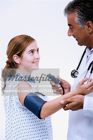 Seitenansicht eines männlichen Arztes Messung des Blutdrucks, einer jungen Frau