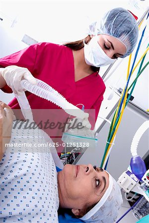 Female surgeon putting an oxygen mask on a female patient's face