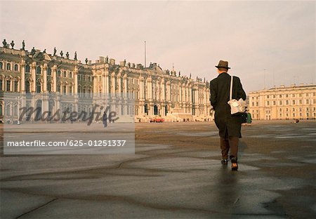 Vue arrière d'un homme marchant devant un palais, le Palais d'hiver, Musée de l'Ermitage, Saint-Pétersbourg, Russie