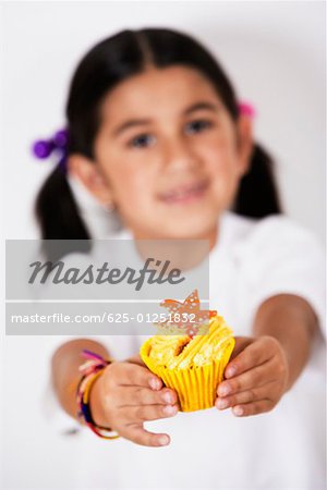 Portrait d'une jeune fille tenant un petit gâteau