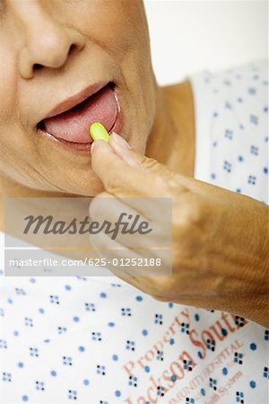 Close-up of a senior woman taking a pill