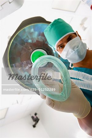 Portrait of a male surgeon holding an oxygen mask