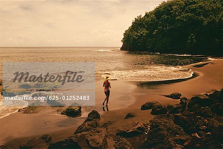 Vue grand angle d'une femme en cours d'exécution sur la plage, Tahiti, îles de la société, Polynésie française
