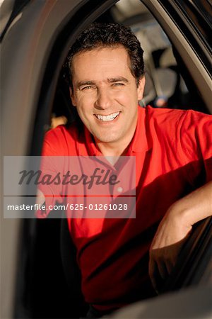 Portrait of a young man sitting in a car and smiling