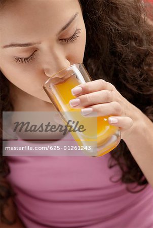 Erhöhte Ansicht einer jungen Frau, ein Glas Saft trinken