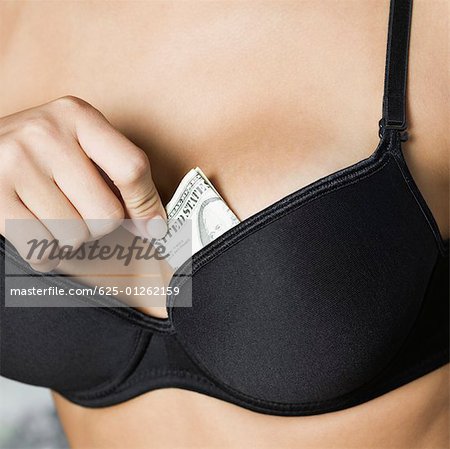 Close-up of a teenage girl putting money in her bra