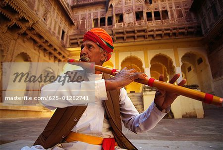 Nahaufnahme eines Reifen Mannes spielt eine Flöte in ein Fort Meherangarh Fort, Jodhpur, Rajasthan, Indien