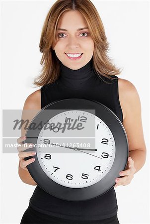 Portrait of a businesswoman holding a clock and smiling