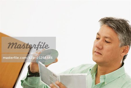 Close-up of a senior man holding a CD and a CD Case