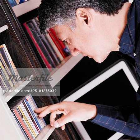 Side profile of a senior man looking for a CD