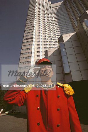 Groom saluant devant un hôtel, préfecture de Tokyo, Japon