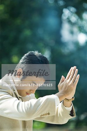 Homme tenant les mains en prière et en s'inclinant la tête