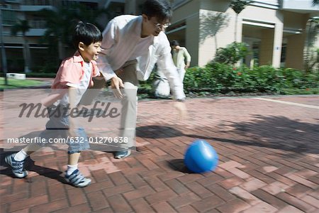 Père et fils, jouer au ballon, flou de mouvement