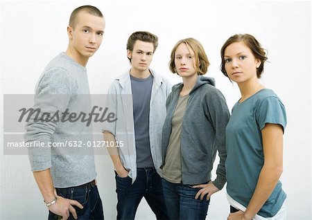 Group of young adults standing with hands on hips, looking at camera