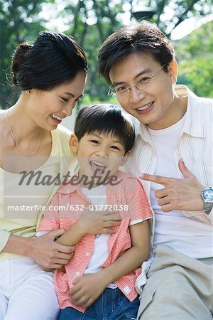 Famille en riant, père pointant au fils, portrait