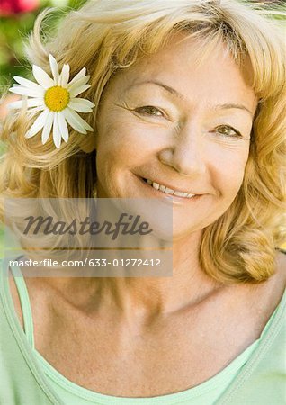 Senior woman with flower behind ear, portrait