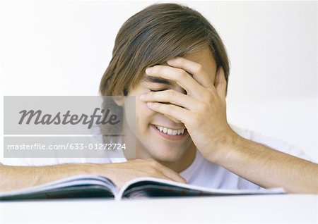 Man with book, covering face