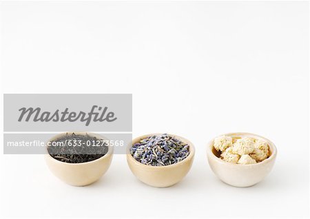 Three calabash bowls containing tea leaves, lavender, and chamomile flowers