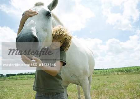 Boy standing with horse