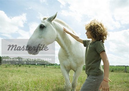 Boy petting horse