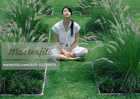 Femme assise dans le jardin d'ornement, les yeux fermés