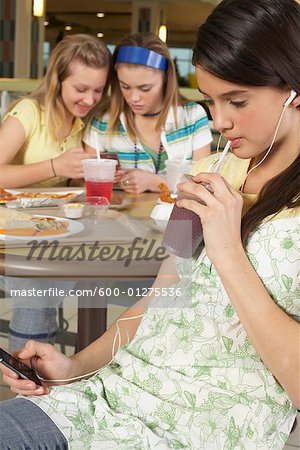 Adolescent écoute de MP3 Player, amis en arrière-plan