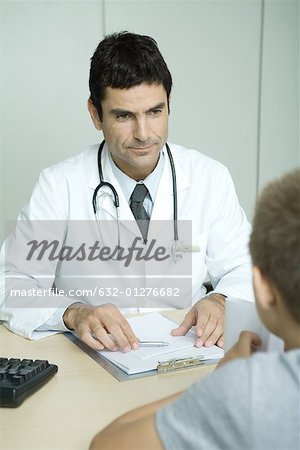 Arzt gegenüber Kind sitzt