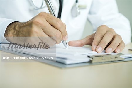 Doctor writing prescription, close-up of hands