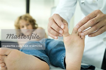 Doctor examining boy's toes